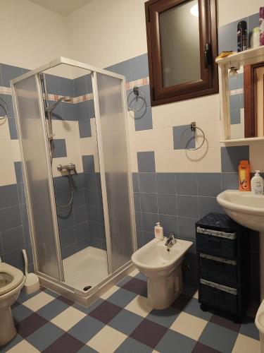 een badkamer met een douche, een toilet en een wastafel bij Anthony's House in Uggiano la Chiesa