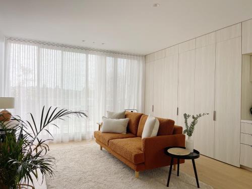 a living room with a couch and a large window at Oakview on Main in Mornington