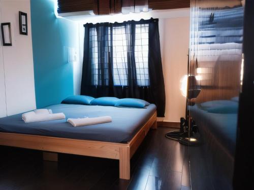 um quarto com uma cama com almofadas azuis e uma janela em RAHEE GUEST HOUSE em Guwahati