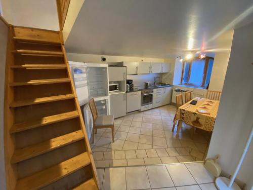 une cuisine avec un escalier et une table dans une pièce dans l'établissement Duplex à 120 m du lac d'Annecy, à Duingt