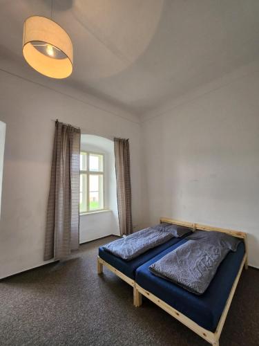 a bedroom with a blue bed in a room at Zámek Ruda nad Moravou in Ruda na Moravě