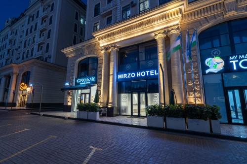 ainia hotelgebouw aan een stadsstraat 's nachts bij MIRZO HOTEL in Tasjkent