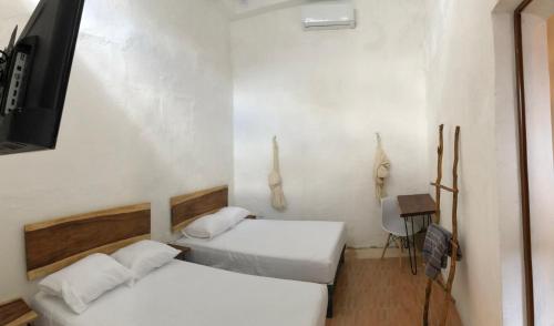 a room with two beds and a tv and a table at Casa Mediterranea in Campeche