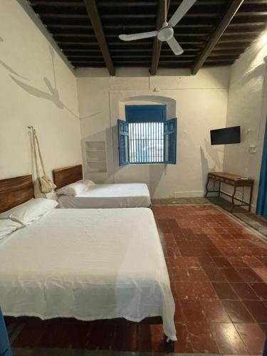 a bedroom with two beds and a ceiling fan at Casa Mediterranea in Campeche