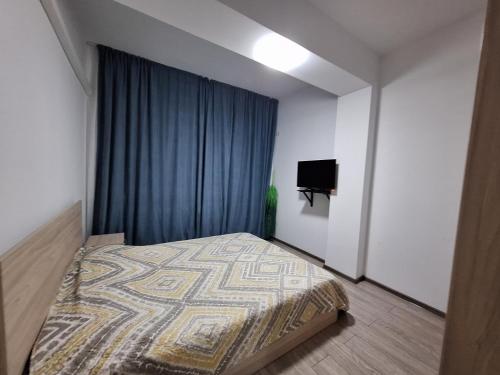 una camera con letto con tenda blu di Moni apartment a Mamaia Nord - Năvodari