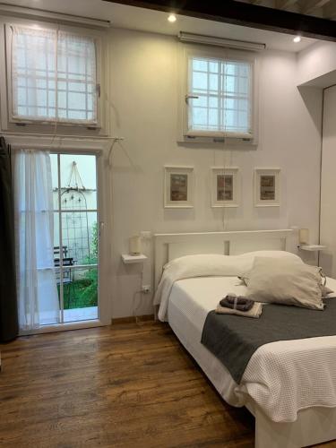 a white bedroom with a bed and a window at San Pierino Charming Rooms in Lucca