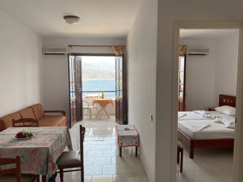 a room with two beds and a view of the ocean at Dolphin Hotel Apartments in Karpathos