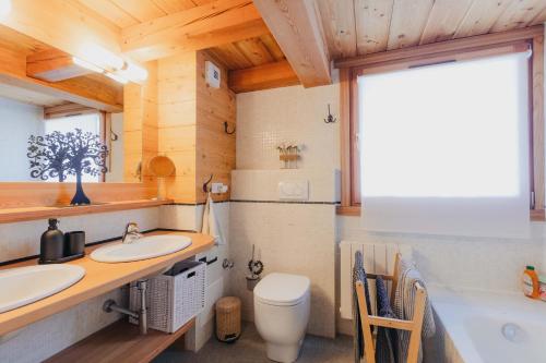 une salle de bain avec deux lavabos et une baignoire et des toilettes dans l'établissement Appartement en résidence standing, ski aux pieds et garage, à Montgenèvre