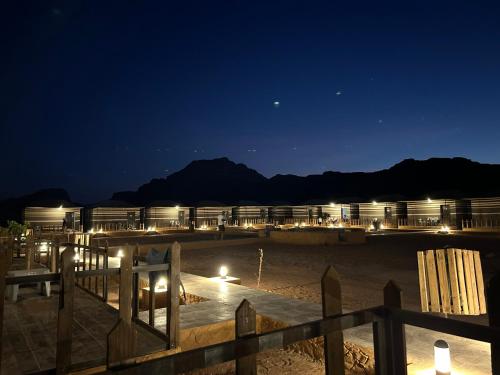 a resort at night with mountains in the background at Panorama Wadi Rum in Wadi Rum