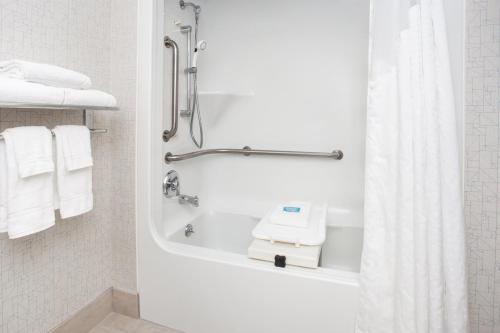 a bathroom with a shower and a bath tub with towels at Holiday Inn Express South Portland by IHG in South Portland