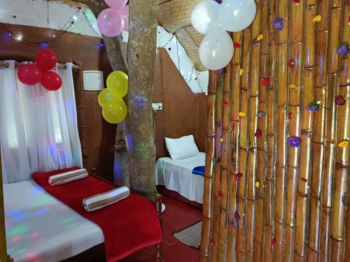 a room with a bunch of balloons and two beds at Kalidasa Tree House and Villa, Wayanad in Chekadi