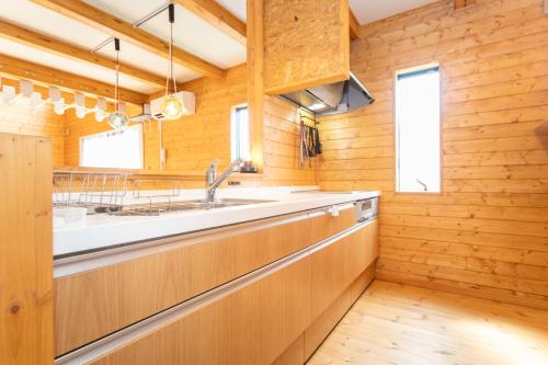 a kitchen with wooden walls and a sink at Awaji Seaview Resort in Nojima in Kusumoto