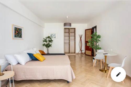 a white bedroom with a bed and a table and chairs at La Dimora dei Teatri, Luxury rooms in Palermo
