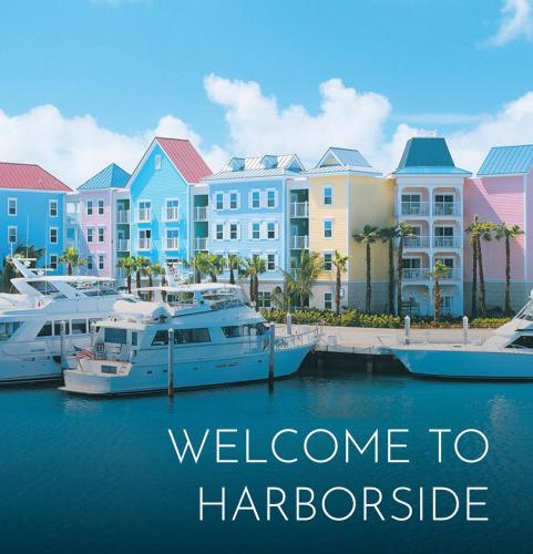 a group of boats docked in a marina with buildings at Harbourside Resort, Paradise Island Bahamas in Nassau
