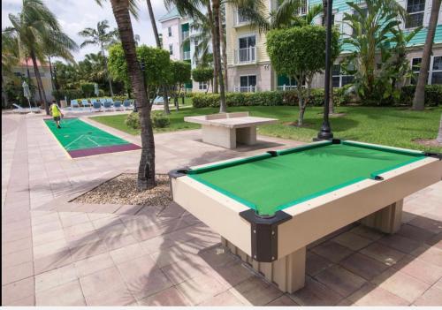 a pool table in a park with palm trees at Harbourside Resort, Paradise Island Bahamas in Nassau