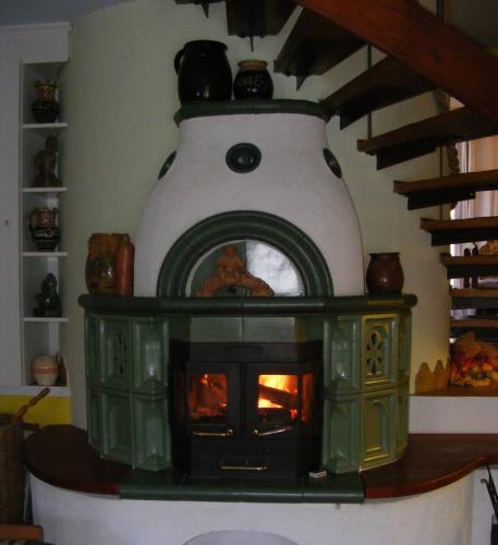 a woodburning stove in a room with a staircase at Panka House in Zalakaros