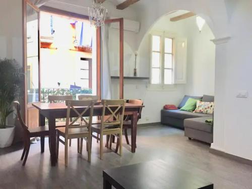 a dining room and living room with a table and chairs at Romantic apartment in the center of Barcelona in Barcelona