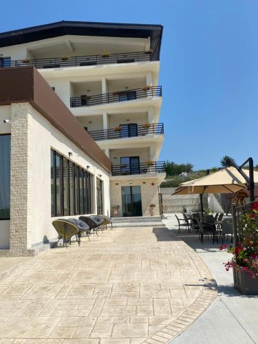 a building with a patio with tables and chairs at Hotel Maya in Horezu