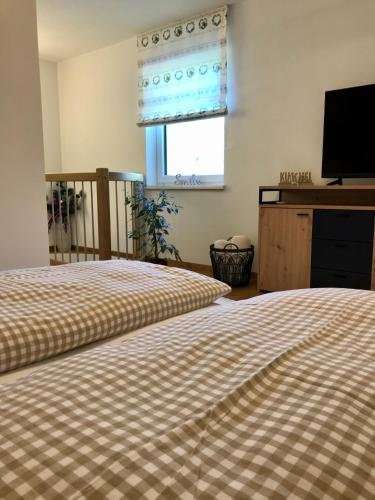 a bedroom with two beds and a flat screen tv at Bio Schartenhof in Sankt Johann im Pongau