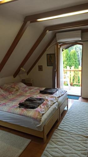 a bedroom with two beds and a large window at Panka House in Zalakaros