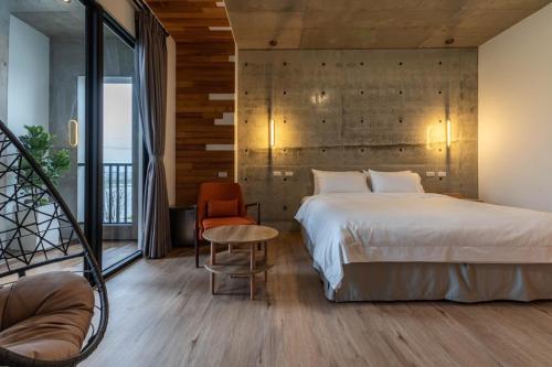 a bedroom with a bed and a table and a chair at 佇沐民宿 in Xingjian