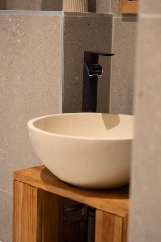 a white bowl sink sitting on top of a wooden cabinet at Villa La Roseraie in Vichy