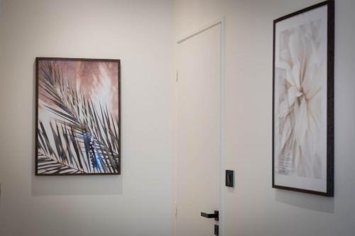 two framed pictures on a wall next to a door at Villa La Roseraie in Vichy