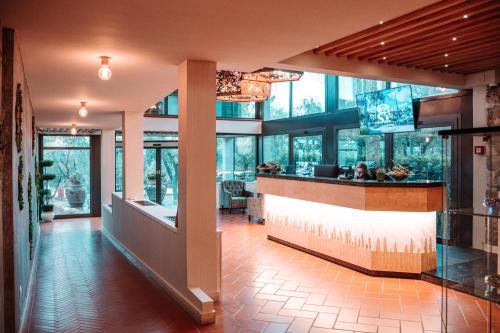 eine Lobby eines Restaurants mit einer Bar und Fenstern in der Unterkunft Villa Cesi Resort & Spa in Impruneta