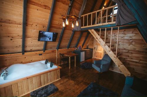 ein Bad mit einer Badewanne und einem TV in einer Hütte in der Unterkunft Rova Suit Bungalov in Rize