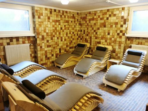 a waiting room with chairs in a room with brick walls at Hotel la Plaza in Corvara in Badia