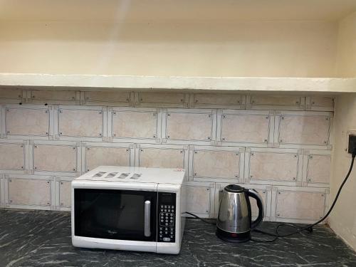 a microwave sitting on the floor next to a wall at Rukmani Home Stay in Mathura