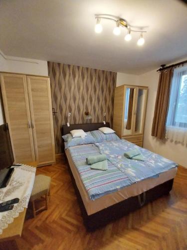 ein Schlafzimmer mit einem großen Bett und einem Tisch in der Unterkunft Simon Apartmanház Zamárdi in Zamárdi