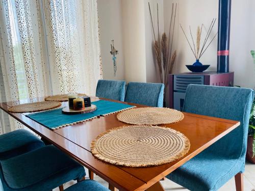 a dining room with a table and blue chairs at Homey Family ArtAki in Néa Artáki