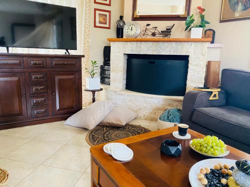 a living room with a couch and a tv at Homey Family ArtAki in Néa Artáki