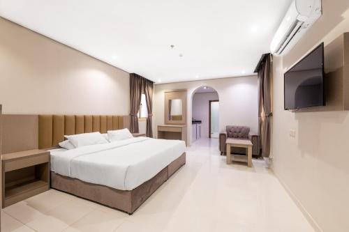 a bedroom with a bed and a flat screen tv at تريبل ستار Triple Star in Qabāʼ