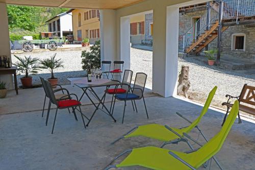 a patio with a table and chairs and a dog at Casa Re - B&B e Vino a Montabone in Montabone