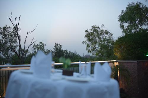 a table with a white table cloth on a fence at Hotel Atulyaa Taj in Agra