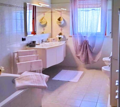 Baño blanco con bañera y lavamanos en B&B Etienne Collepardo, en Collepardo