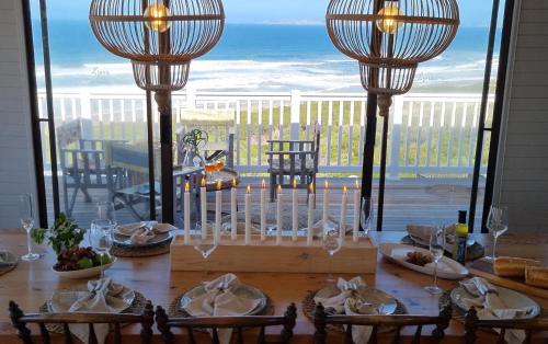 mesa de comedor con vistas al océano en Seaview Beach House - 7 on Lynx, Great Brak River, en Groot Brak Rivier
