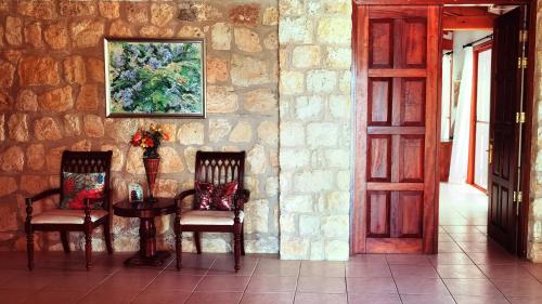 a table and two chairs in a room with a stone wall at Beautiful Home in Paphos City