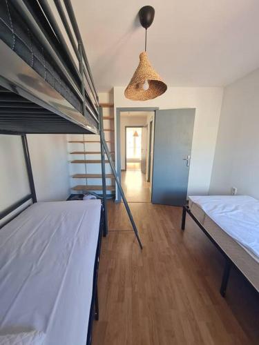 Cette chambre comprend 2 lits superposés et un couloir. dans l'établissement T3 Duplex Quartier des artistes., à Sète