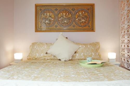 ein Bett mit zwei Kissen und ein Buch darauf in der Unterkunft Incantevole ed elegante appartamento a Niguarda! in Mailand