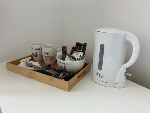 ein Tablett mit Tassen, einer Kaffeekanne und einem Mixer in der Unterkunft Withy Farm in Canterbury
