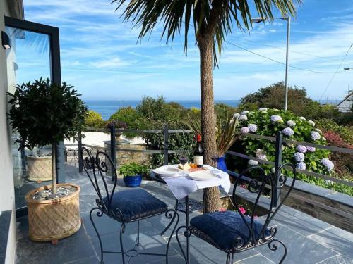 a table and chairs on a patio with a view of the ocean at Mevagissey Boutique Flatlet with sea and countryside views in Mevagissey