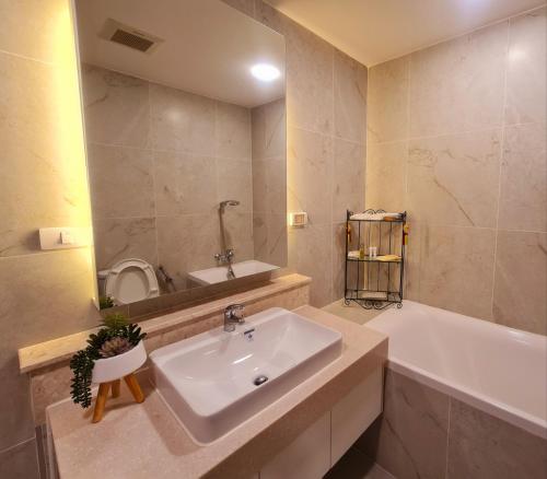 a bathroom with a sink and a tub and a mirror at 2 Bedroom apartment near Chiang mai Night Bazzar in Chiang Mai