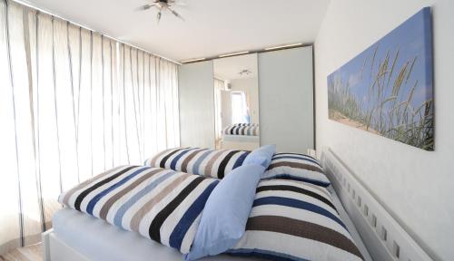 a room with three striped pillows and a mirror at Lichtdurchflutete Ferienwohnung mit Südbalkon in Wangerooge