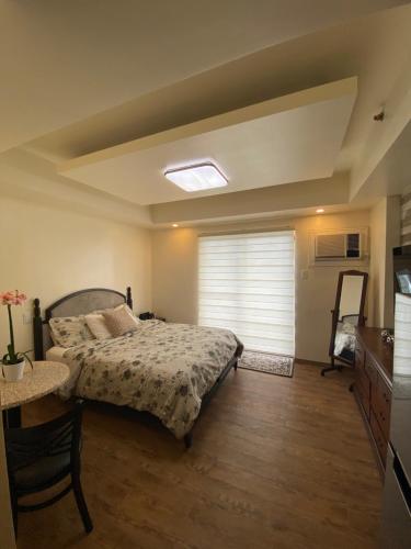 une chambre avec un lit, une table et une fenêtre dans l'établissement Seaview Amani Grand Resort Residences 3-5mins from airport, à Mactan