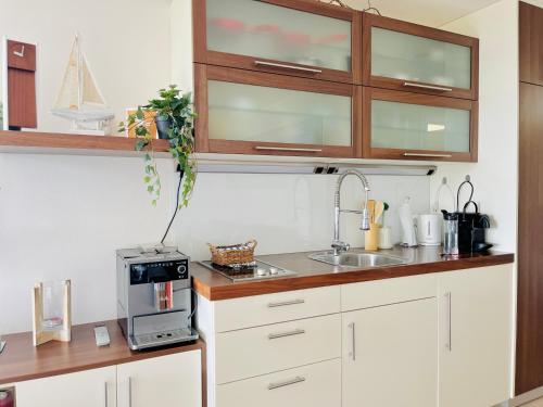 a kitchen with white cabinets and a sink at Penthaus Horizont mit Meerblick in Lübeck