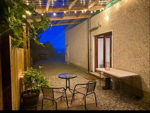 a patio with a table and chairs in a building at Yellow door cottage in Moville