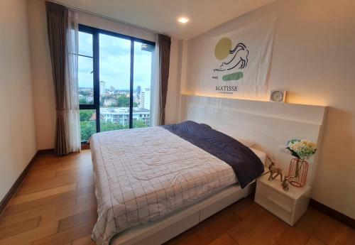 a bedroom with a bed and a large window at 2 Bedroom apartment near Chiang mai Night Bazzar in Chiang Mai